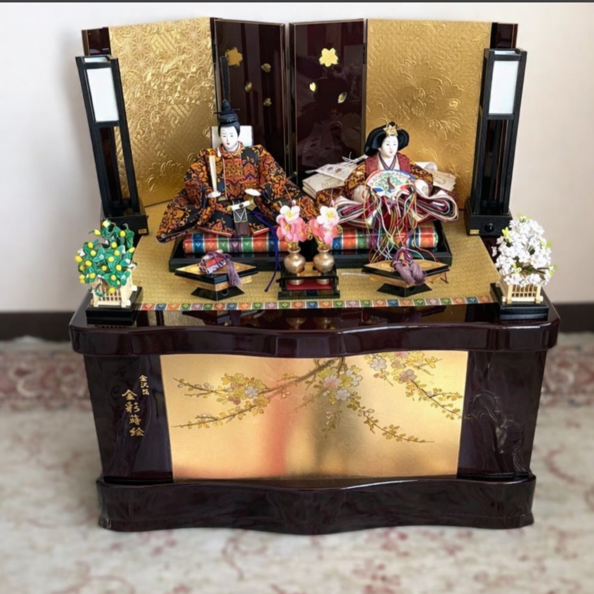 ⁡
金屏風と蒔絵調の華やかな意匠が美しい、親王飾りのひな人形です

飾り台はそのまま収納箱になる便利な収納飾りタイプで、シーズンオフはすっきりと片付けていただけます

落ち着いた色味のお内裏様・お雛様は上品で優しいお顔立ち。
⁡

ぼんぼり・桜橘・屏風など一式揃っており、コンパクトながら存在感のあるお飾りです。
⁡
⁡